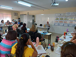 Foto da professora Magda Soares dando aula com a sala cheia
